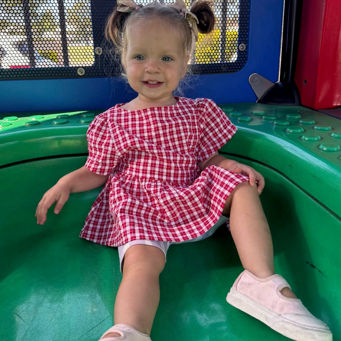 Isabel wearing Poppy Dress in Ruby Check. Age 12-18m • Wearing 6-12m