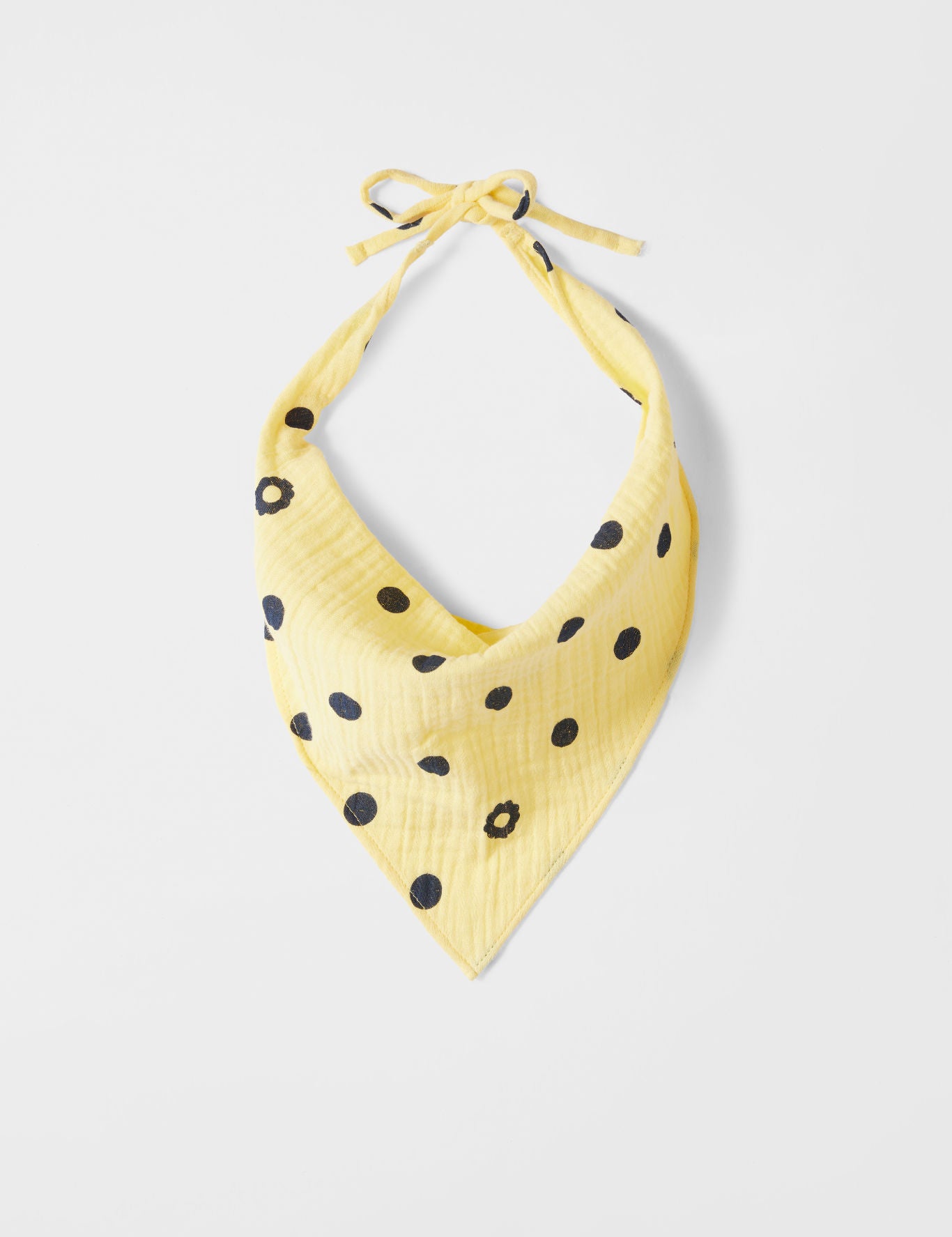 Yellow bandana with black polka dots on a light gray background