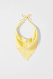 Yellow halter top on a light gray background