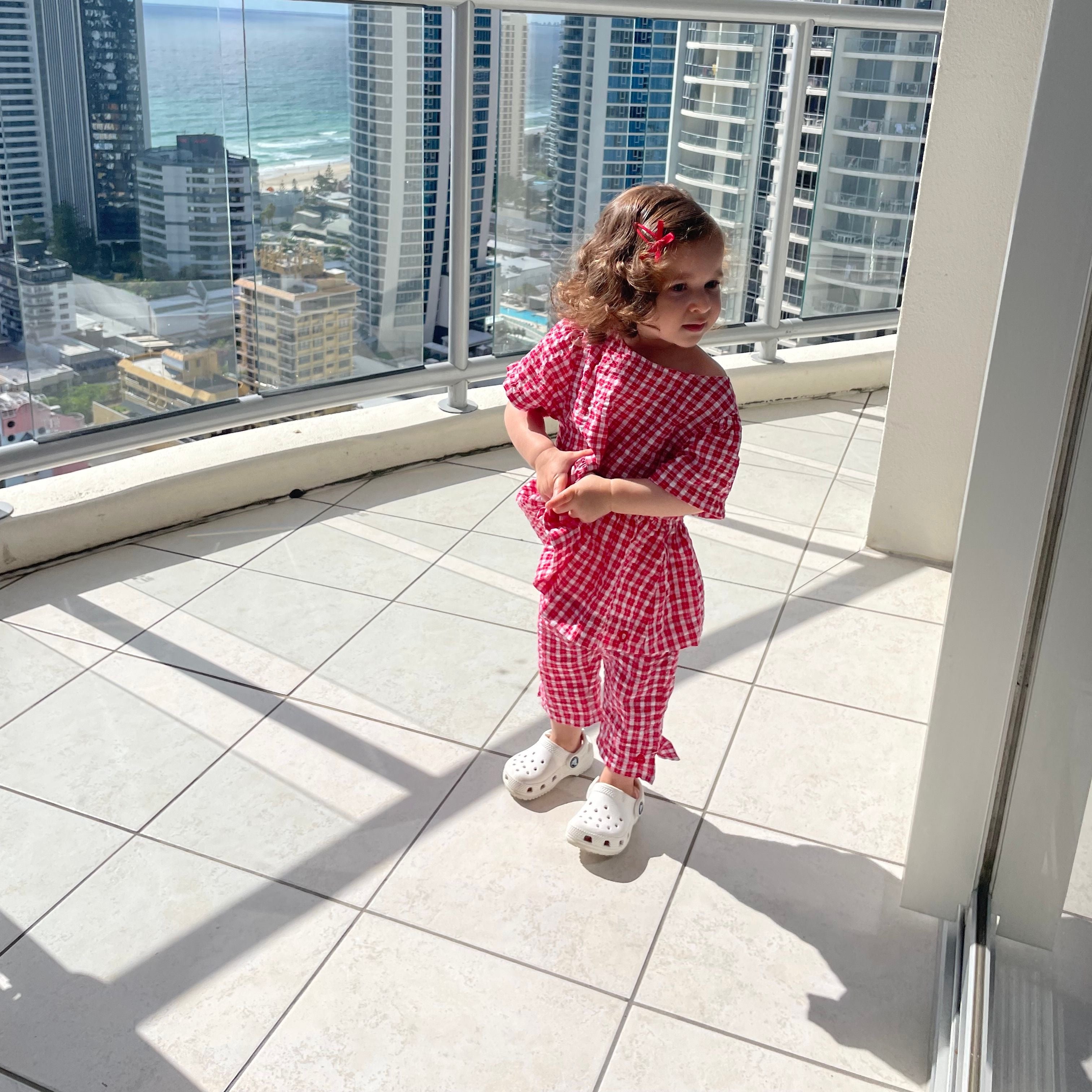 Amani wearing Poppy Top in Ruby Check. Age 2 • Wearing 2-3Y